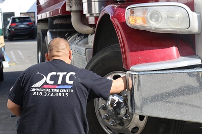 technician checking tire on truck